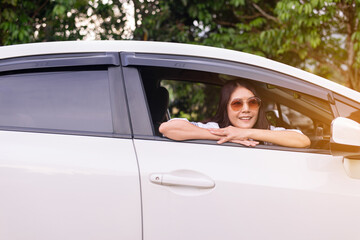 Happy asian woman sitting in the car looking out window,Car insurance concept