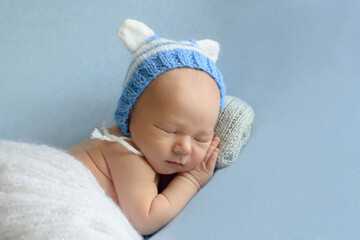 Newborn baby boy in a blue knitted hat.