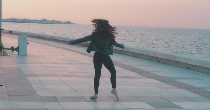 Ballerina on seaside. Grace, tutu concept in beautiful sunset time, outdoor. Dancer female with ocean.
