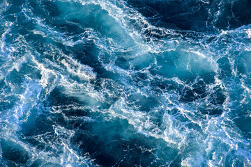 Stormy ocean waves backlit by the light of the setting sun. Transparent. Navy blue. Blue....