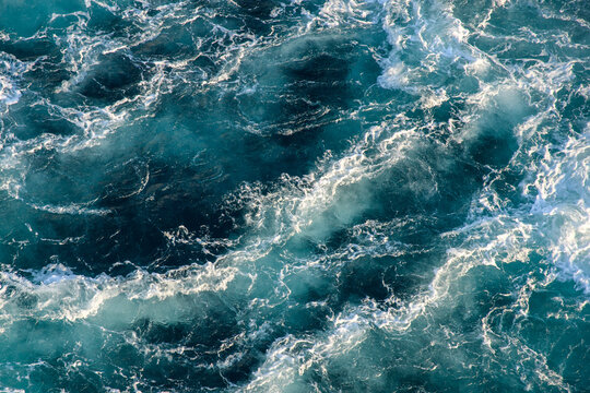 Stormy ocean waves backlit by the light of the setting sun. Transparent. Navy blue. Blue. Background. Pattern. © DOF
