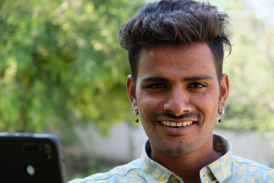 View Of An Indian Man Wearing A Green Shirt With Short Hair Looking At The Camera And Smiling