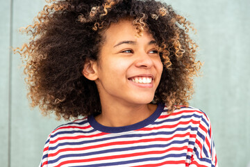 Close up happy African American girl with afro hair looking away