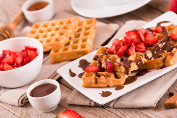 Waffles with strawberries and chocolate cream.
