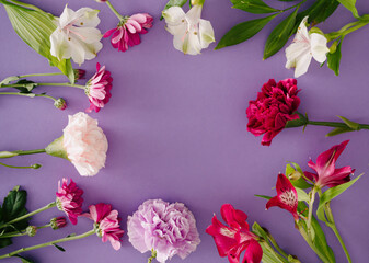 Various spring flowers on pastel purple background. Creative nature concept.