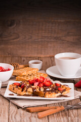 Waffles with strawberries and chocolate cream.