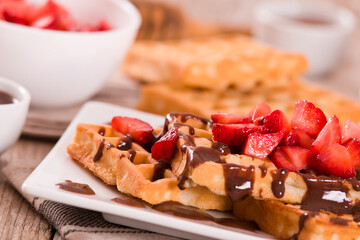 Waffles with strawberries and chocolate cream.