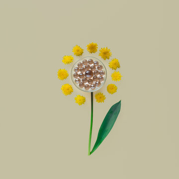 Futuristic flower with glass pearls in the center and with dandelion petals on beige background.