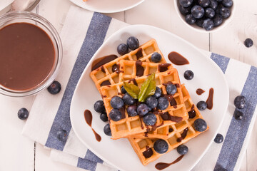 Waffles with blueberries and chocolate cream.
