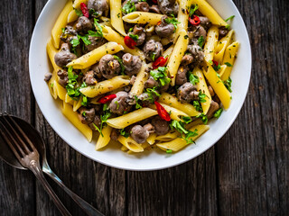 Penne with mushrooms in cream sauce on wooden table
