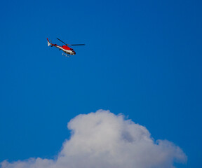 Fototapeta na wymiar Helicopter flying in a beautiful blue sky photographed with a telephoto lens