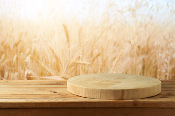 Empty wooden log on rustic table over wheat field background.  Jewish holiday Shavuot mock up for design and product display.