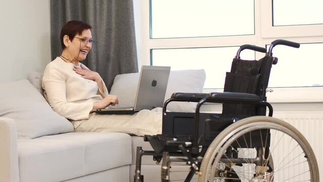 Handicapped woman with lapot lay on couch