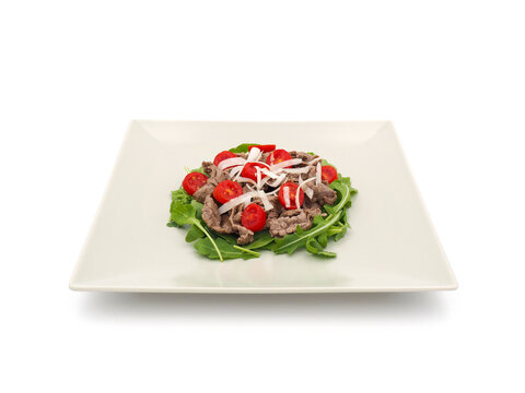 Beef strips with rucola and tomatoes isolated on white background