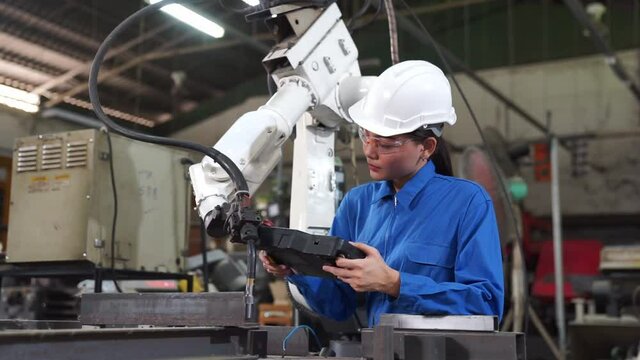 Engineer check and control welding robotics automatic arms machine in intelligent factory industrial.