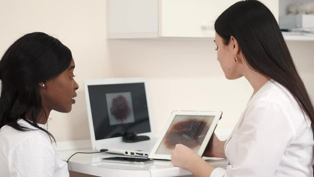 Woman with tablet computer explaining something to client