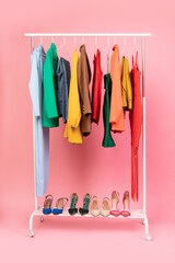 Vertical Shot Of Clothing Rail With Clothes Over Pink Background