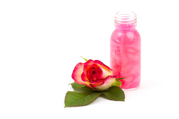 bath oil and pink roses on white background