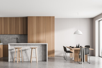 Light kitchen interior with table and chairs on concrete floor