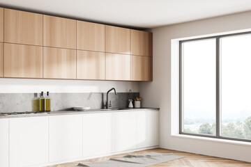 Stylish interior of bright and white modern kitchen room. Parquet wooden floor.