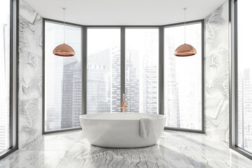 Modern Bathroom interior in new luxury home. Stylish hotel room. Open space area. Marble walls and floor. White bathtub. Panoramic window.