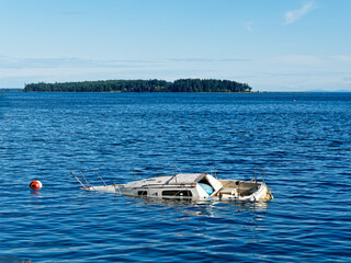 Sunken boat floats in the coastal waters near shore of Sidney BC