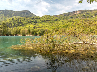Vue sur un lac au milieu de la nature , des arbres, des fleurs et de la montagne à Carros dans le Sud de la France près de Nice