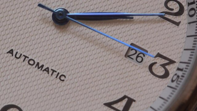 Automatic watch movement closeup macro showing with time hands moving