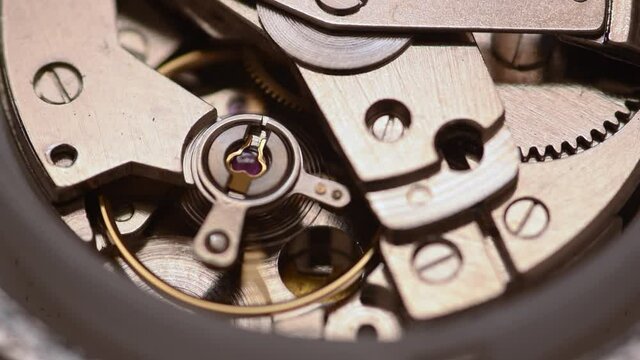 Automatic watch movement closeup macro showing hair balance spring moving and ruby jewels