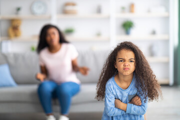 Little black girl feeling angry, taking offence at her mother at home, copy space. Parent child conflict concept - obrazy, fototapety, plakaty