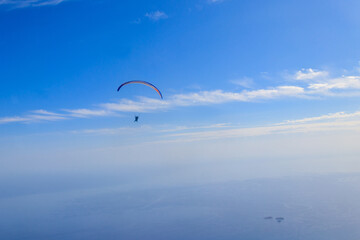 Paragliders in blue sky. Concept of active lifestyle and extreme sport adventure