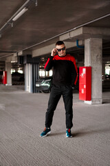 Fototapeta premium A young man in a sports uniform in an underground parking lot.