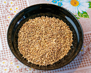 Buckwheat in a black plate on the table.