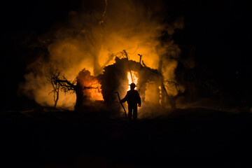 Fototapeta premium Old stone house burning uncontrollable in the night. A fire in a country house. Creative artwork decoration.