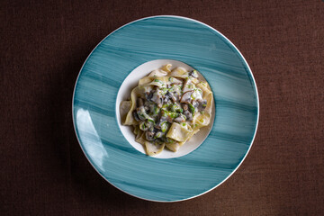 pasta with mushroom sauce on a blue plate view from top