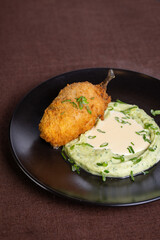 mashed potatoes with cutlet on Kiev on a black plate