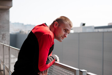 Young man in sports uniform in the parking lot. City view