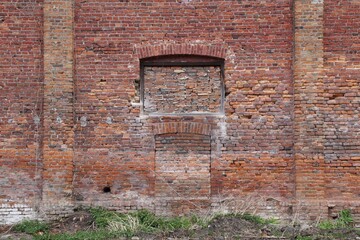 wall of the red brick building with bricked up window and entrance