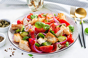 Traditional italian tomato salad panzanella with mozzarella, capers, red onion and croutons. Summer salad.