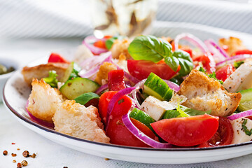 Traditional italian tomato salad panzanella with mozzarella, capers, red onion and croutons. Summer salad.