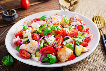 Tuscan Panzanella, traditional Italian salad with tomatoes and bread on wooden background. Vegetarian panzanella salad. Mediterranean healthy food.