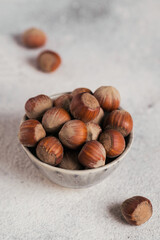 Pile of hazelnuts filbert in a bowl on a white background