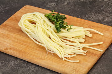 Chechil spaghetti cheese over board