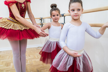 Group of beautiful little girls practicing ballet at dancing class.