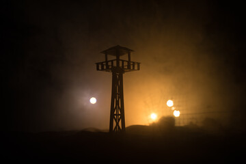 Creative artwork decoration. Silhouette of army watchtower at night. Selective focus