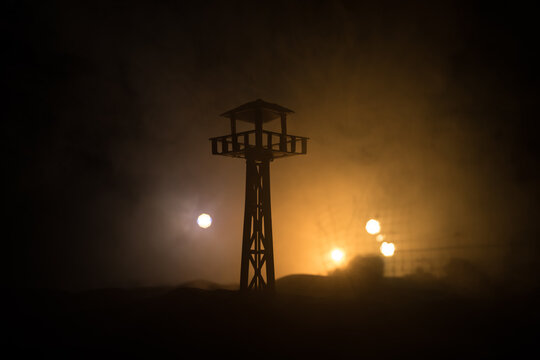 Creative artwork decoration. Silhouette of army watchtower at night. Selective focus
