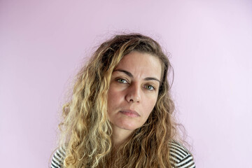 Facial expression of Brazilian woman on pink background.