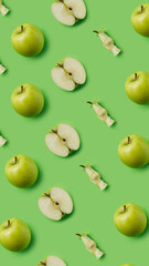 Pattern made with fresh green eaten apples and halves on the green background. Minimal organic fruit concept. Flat lay, top view.