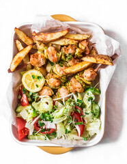 Delicious tapas, appetizer - chicken skewers with zucchini, fresh vegetable salad and baked potatoes on a light background, top view