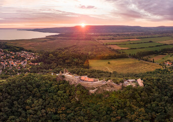 Fototapeta na wymiar Aerial 4k drone view of the castle of Szigliget at sunset, a medieval fortress on a hill in Balaton Uplands, Hungary